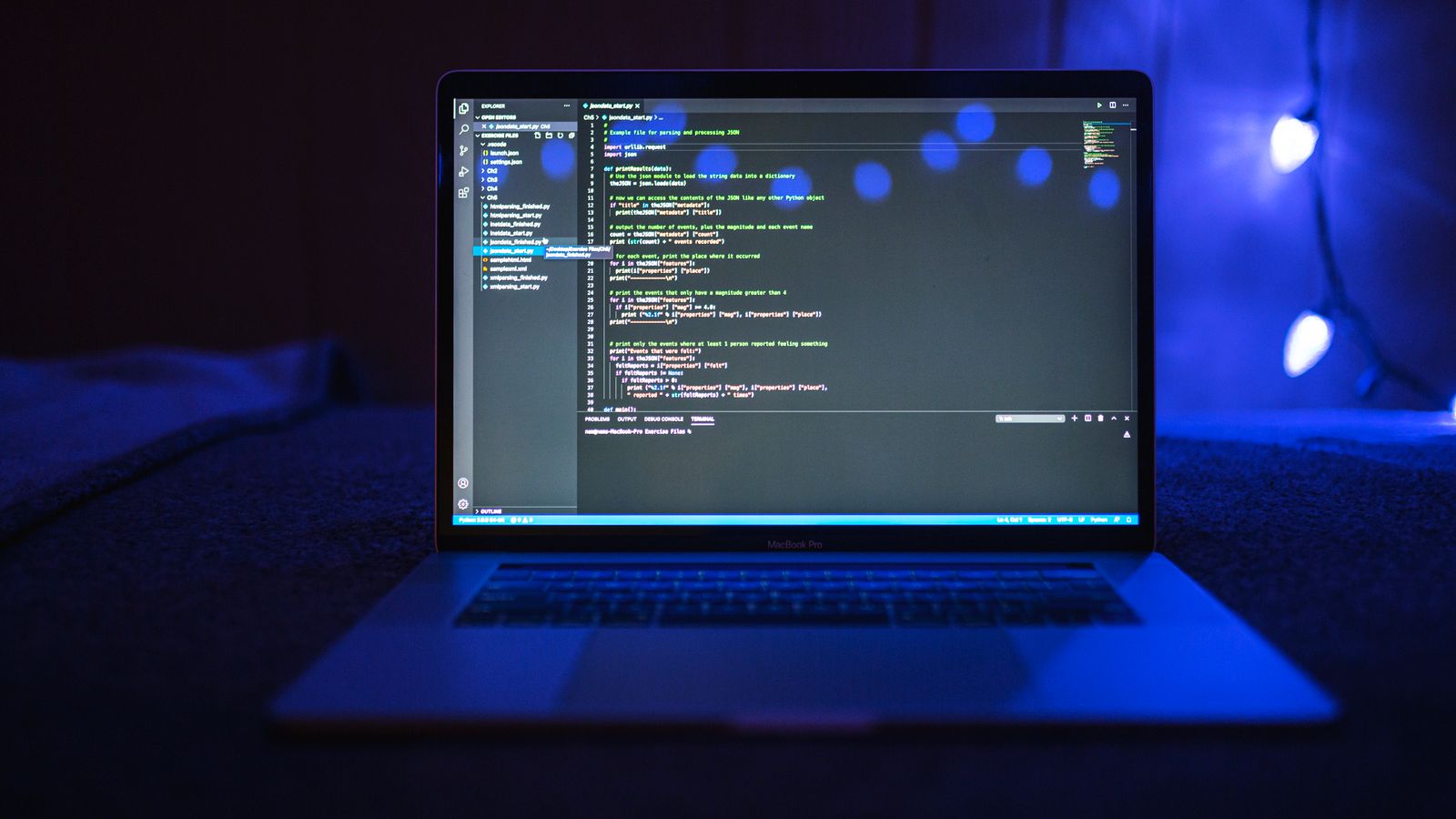 A close view of software code displayed on a laptop screen in a dark workspace