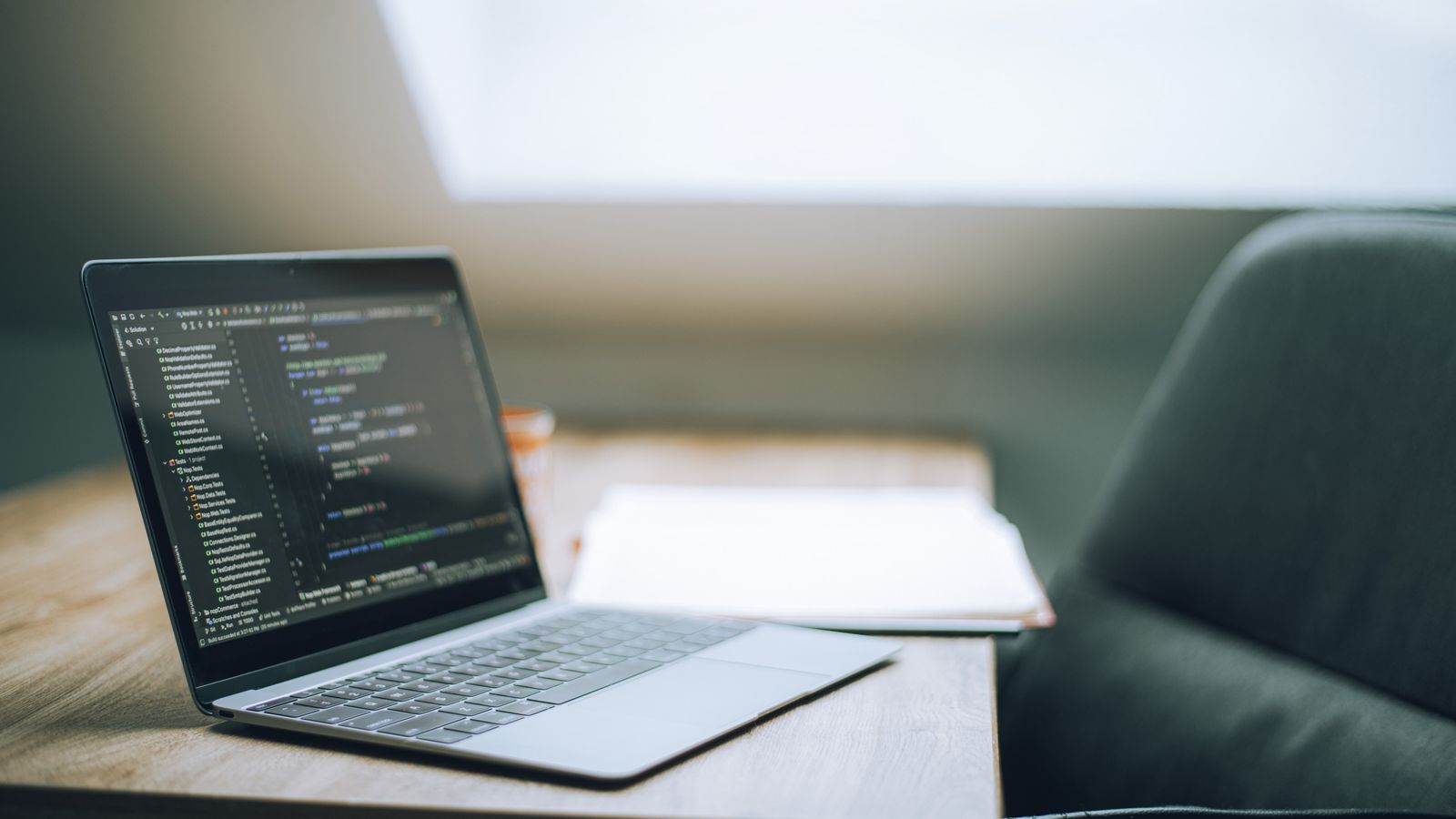An open laptop showing software code in a bright, minimal workspace