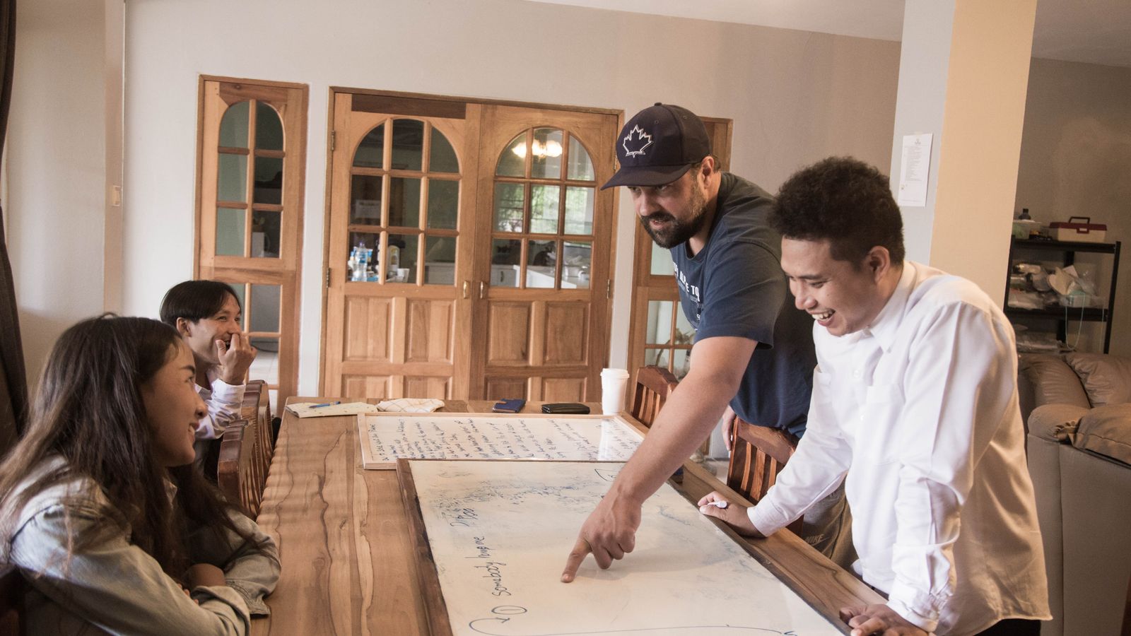 A diverse product team planning together around a whiteboard laid across a table
